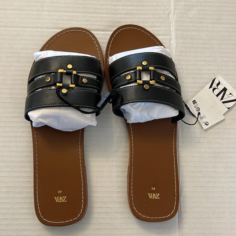 Black leather flat sandal with gold metal detail